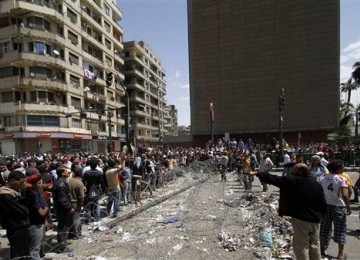 Pengunjuk rasa menyingkirkan kawat berduri yang memblokade Tahrir Square, Senin (11/4).