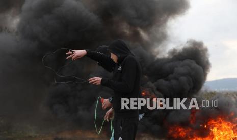  Pengunjuk rasa Palestina bentrok dengan pasukan Israel selama demonstrasi menentang pemukiman Israel di tanah desa Beita, dekat kota Nablus, Tepi Barat, 11 Februari 2022. 