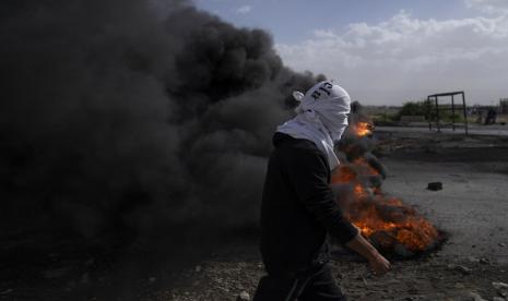 Pengunjuk rasa Palestina memblokir jalan utama dengan membakar ban di kota Tepi Barat 0f Jericho, Senin, 6 Februari 2023. Pasukan Israel membunuh lima pria bersenjata Palestina dalam serangan di sebuah kamp pengungsi di Tepi Barat yang diduduki pada hari Senin, pertumpahan darah terbaru di wilayah yang kemungkinan akan semakin memperburuk ketegangan. 