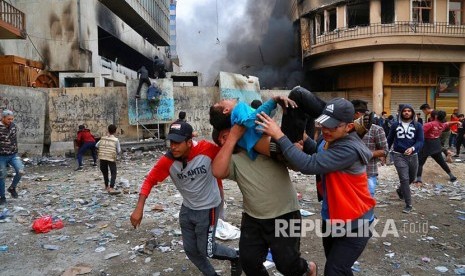 Pengunjukrasa yang terluka dievakuasi menjauhi lokasi  unjukrasa di Baghdad, Irak, Kamis (28/11).