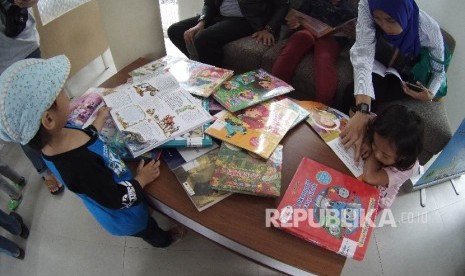   Pengunjung anak-anak membaca buku di Perpustakaan Gasibu, di kawasan Lapangan Gasibu, Kota Bandung, Ahad (18/9). 