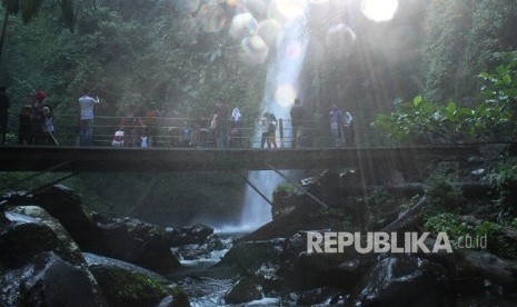 Pengunjung beraktivitas di dekat air terjun, kawasan Taman Nasional Gunung Gede dan Pangrango, di Sukabumi, Jawa Barat, Senin (18/6).