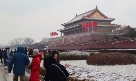 Pengunjung beraktivitas di lokasi objek wisata Kota Terlarang, Beijing, Cina, beberapa saat setelah hujan salju, Kamis (14/2/2019) petang.