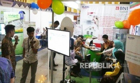 Pengunjung berbincang dengan petugas stan Festival Ekonomi Syariah (FESyar) Regional Jawa, di Aula Pusdai, Kota Bandung.