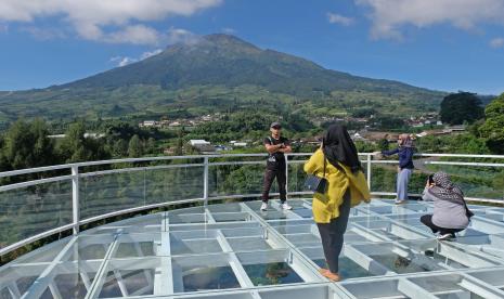 Pengunjung berdiri di jembatan kaca kompleks wisata alam Sigandul View kawasan lereng gunung Sindoro desa Tlahab, Kledung, Temanggung, Jawa Tengah, Senin (30/5/2022). Wisata alam di jalur menuju dataran tinggi Dieng tersebut menjadi destinasi wisata baru yang menawarkan keindahan dan kesejukan udara pegunungan.