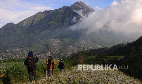 Pengunjung berfoto dengan latar belakang Gunung Merapi di Selo, Boyolali, Jawa Tengah, Selasa (3/7).