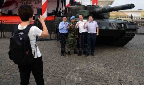 Pengunjung berfoto didekat tank Leopard yang dipajang disamping panggung di Tugu Monas, Jakarta, Jumat (29/8). (Republika/Agung Supriyanto)