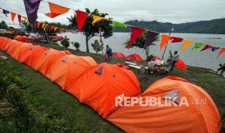 Pengunjung berjalan di depan kemah di kawasan Danau Laut Tawar (Lut Tawar) Takengon, Aceh Tengah, Aceh, Ahad (19/12/2021). Dinas Kebudayaan dan Pariwisata Aceh (Disbudpar) Aceh mematangkan persiapan penyelenggaraan lomba sepeda wisata Tour de Aceh yang dijadwalkan berlangsung di Kabupaten Aceh Tengah pada 14 Mei 2022.