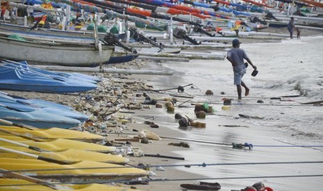 Pengunjung berjalan di pinggiran pantai Senggigi yang dipenuhi sampah di Desa Senggigi, Kecamatan Batulayar, Gerung, Lombok Barat, NTB