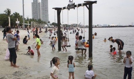 Pengunjung bermain air di kawasan Pantai Karnaval Ancol. (ilustrasi)