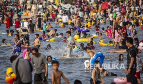 Pengunjung bermain air di Pantai Karnaval Ancol, Jakarta, Kamis (6/6/2019).