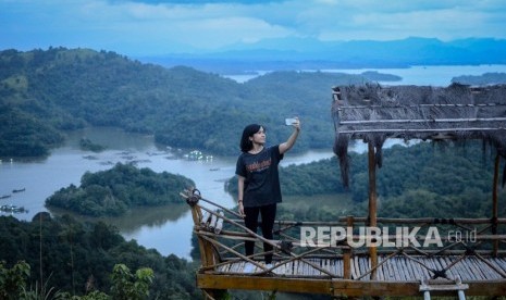 Pengunjung berswafoto dengan latar belakang Waduk Riam Kanan di wisata alam Bukit Matang Kaladan, Banjar, Kalimantan Selatan, Ahad (14/4/2019).