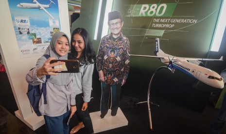 Pengunjung berswafoto dengan patung Presiden Indonesia ke-3 B.J Habibie saat menghadiri Jabar Habibie Festival di Universitas Telkom, Kabupaten Bandung, Jawa Barat, Sabtu (1/12/2018). 