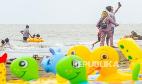 Pengunjung berswafoto di destinasi wisata Pantai Sedari, Cibuaya, Karawang, Jawa Barat, Ahad (5/9/2021). Kemenparekraf terus berupaya mewujudkan pariwisata dan ekonomi kreatif yang berkualitas serta berkelanjutan melalui tiga pilar pemulihan yaitu inovasi, adaptasi dan kolaborasi untuk mempercepat pemulihan ekonomi nasional khususnya sektor pariwisata.