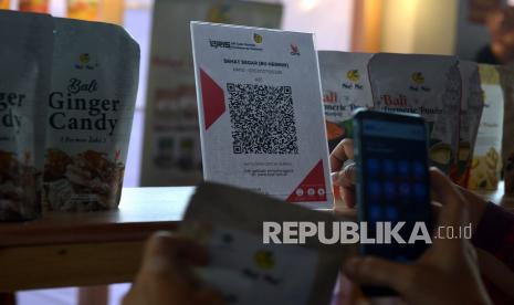 Pengunjung bertransaksi pembayaran produk UMKM secara digital dengan menggunakan Quick Response Code Indonesian Standard (QRIS) dalam rangkaian kegiatan Bali Jagaditha Culture Week di Denpasar, Bali. Kantor Perwakilan Bank Indonesia Provinsi Bali optimistis target merchant pengguna QRIS tahun ini tercapai.