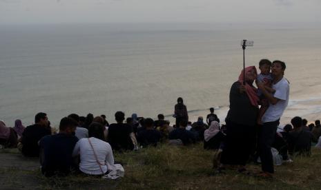 Pengunjung berwisata di Bukit Paralayang Watugupit, Giricahyo, Purwosari, Gunungkidul, D.I Yogyakarta. Watugupit dengan panorama garis Pantai Selatan dari ketinggian tersebut merupakan salah satu destinasi wisata alam andalan di Kabupaten Gunung Kidul. 