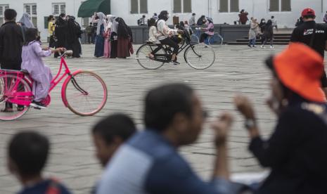 Pengunjung berwisata di Museum Sejarah Jakarta, kompleks Kota Tua, Jakarta. Pengunjung Kota Tua di Jakarta Barat ramai di hari pertama Tahun Baru 2022 pada Sabtu meski area pelataran ditutup dengan garis pembatas melingkari Taman Fatahillah di depan Museum Sejarah Jakarta. Pengunjung tetap berwisata sambil bersepeda, berfoto dengan seniman peran dan ada yang berkunjung ke museum di sekitar.