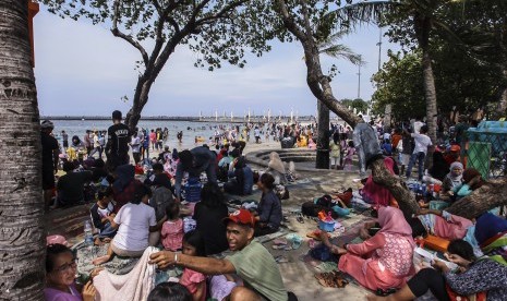 Pengunjung dari berbagai daerah memadati Pantai Festival Taman Impian Jaya Ancol, Jakarta, Senin (26/12). 