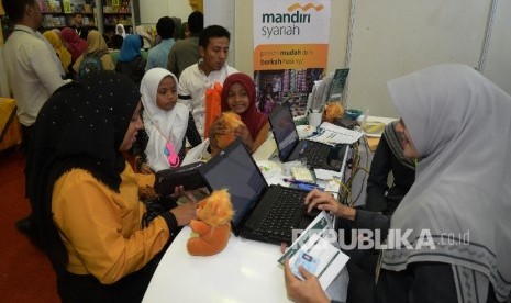 Pengunjung Islamic Book Fair (IBF) 2017 tengah mengisi aplikasi pembukaan rekening di booth Bank Syariah Mandiri (BSM) di IBF JCC Senayan, Jakarta, Kamis (4/5). 