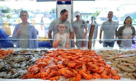 Pengunjung melihat beragam seafood segar di Pasar Ikan Sydney, Australia.