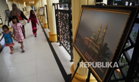  Pengunjung melihat karya fotografi yang dipamerkan pada koridor Islamic Center, Mataram, Lombok, Ahad (28\5). 