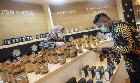 Pengunjung melihat-lihat kopi yang dijual di salah satu stan peserta Indonesia Sharia Economic Festival (ISEF) ke-8 Tahun 2021 di Jakarta Convention Center (JCC), Senayan, Jakarta, Rabu (27/10). Pemerintah mengungkapkan potensi industri halal di Indonesia. 