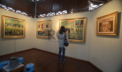 Pengunjung melihat-lihat lukisan betawi di Pendopo Batik, Museum Tekstil, Jakarta barat, Ahad, (7/12). Selain pameran lukisan yang dilukis oleh Sarnadi Adam dengan tema 