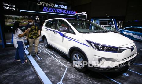 Pengunjung melihat mobil Toyota Kijang Innova Listrik yang dipamerkan pada pembukaan IIMS Hybrid 2022 di JiExpo Kemayoran, Jakarta, Kamis (31/3/2022). Pameran otomotif Indonesia International Motor Show (IIMS) Hybrid 2022 yang berlangsung pada 31 Maret-10 April itu digelar secara daring (online) dan kunjungan langsung dengan pembatasan kapasitas dan penerapan protokol kesehatan COVID-19. 