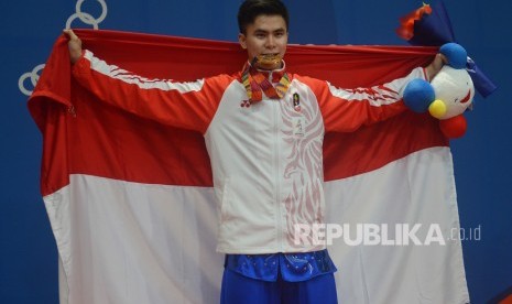 Atlet wushu Indonesia Edgar Xavier Marvelo menggigit medali setelah memenangi nomor Wushu Gunshu Putra SEA Games ke-30 di gedung World Trade Center Manila, Filipina, Selasa (3/12/2019).