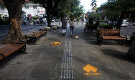 Pengunjung melintas di dekat tanda jaga jarak dan jalan satu arah di Kawasan Wisata Malioboro, Yogyakarta. Pemerintah Daerah Istimewa Yogyakarta mencatat jumlah kasus pasien dalam pengawasan yang terkonfirmasi positif COVID-19 pada Sabtu (20/6) bertambah delapan orang sehingga total menjadi 285 kasus.