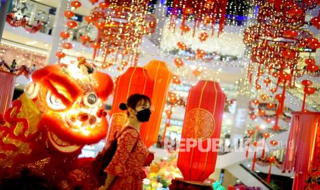 Pengunjung melintas di hadapan patung barongsai di Pavillion Mall, Kuala Lumpur, Malaysia, Selasa (1/2/2022). (Ilustrasi)