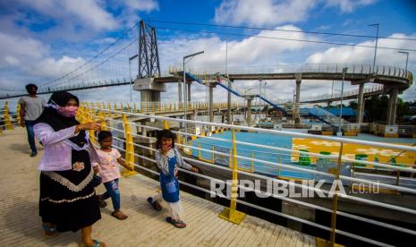 Pengunjung melintas di jembatan Antasan Bromo, di Banjarmasin, Kalimantan Selatan, Senin (4/1/2021). Pemerintah Kota Banjarmasin menegaskan, tidak ada izin bagi tempat wisata buka pada libur Hari Raya Idul Fitri 1442 hijrah, karena pandemi Covid-19.