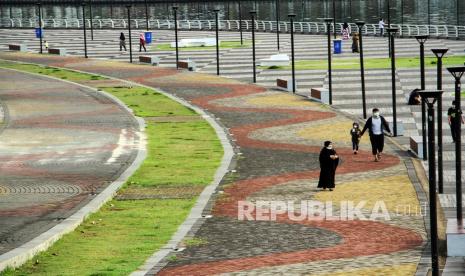 Pengunjung melintas di kawasan wisata Lego-Lego, Makassar, Sulawesi Selatan, Kamis (17/2/2022). Pemerintah setempat membatasi jumlah pengunjung di ruang publik sebesar 50 persen setelah diberlakukannya Penerapan Pembatasan Kegiatan Masyarakat (PPKM) level tiga hingga 28 Februari 2022 dalam rangka menekan lonjakan kasus COVID-19. 