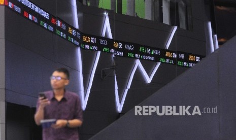 Pengunjung melintas didekat layar pergerakan Indeks Harga Saham Gabungan (IHSG) di Gedung Bursa Efek Indonesia (BEI), Jakarta, Selasa (4/4). 