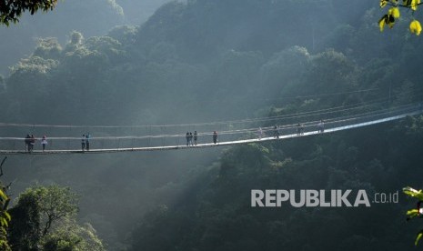 Visitors cross a long suspension bridge in the area of Gunung Gede and Pangrango National Park, in Sukabumi, West Java.