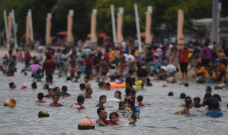 Pengunjung memadati kawasan Pantai Ancol di Taman Impian Jaya Ancol, Jakarta, Selasa (3/5/2022). Objek wisata tersebut kembali ramai dikunjungi wisatawan pada saat liburan Hari Raya Idul Fitri 1443 H setelah dua tahun sebelumnya sempat mengalami penurunan kunjungan wisatawan akibat pandemi COVID-19.