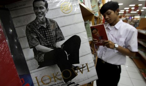 Pengunjung membaca buku tentang Jokowi di salah satu toko buku di Tangerang, Banten, Selasa (18/8).