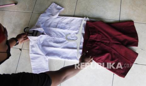 Pengunjung memilih baju seragam sekolah bekas pakai yang dijual di kawasan Gilingan, Solo, Jawa Tengah, Jumat (10/9/2021). Selama masa dimulainya Pembelajaran Tatap Muka, pedagang setempat mengaku baju seragam sekolah bekas yang dijual seharga Rp15 ribu sepasang tersebut banyak diminati pembeli karena lebih murah dari harga baju seragam baru dengan harga Rp80 ribu sepasang. 