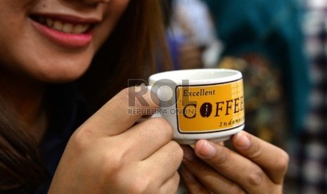 Pengunjung meminum kopi saat pencanangan Hari Kopi Internasional di Jakarta, Kamis (1/10).