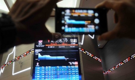 Pengunjung memotret layar pergerakan Indeks Harga Saham Gabungan (IHSG) di kantor Bursa Efek Indonesia (BEI), Jakarta.