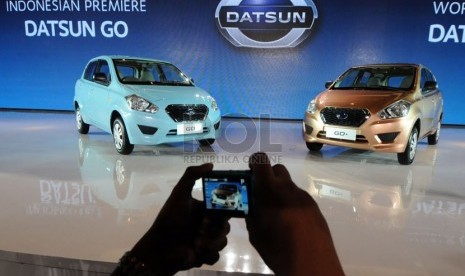  Pengunjung memotret mobil 'Low Cost Green Car' (LCGC) keluaran Datsun yang diluncurkan di Jakarta, Selasa (17/9).  (Republika/Aditya Pradana Putra)