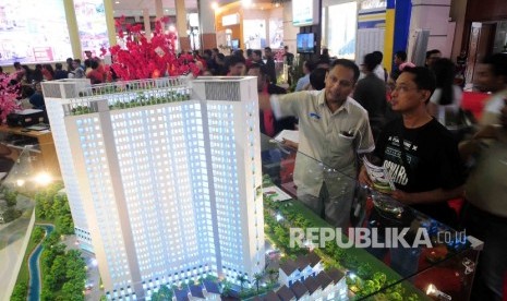 Pengunjung memperhatikan miniatur gedung apartemen saat pameran properti di Jakarta Convention Center (JCC) Jakarta, Ahad (14/2).