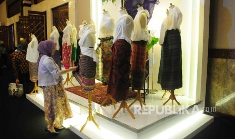 Pengunjung memperhatikan salah satu produk kreatif yang dipamerkan dalam pameran ekonomi kreatif Usaha Mikro Kecil Menengah (UMKM) binaan BI di Balai Kartini, Jakarta, Jumat (26/8).