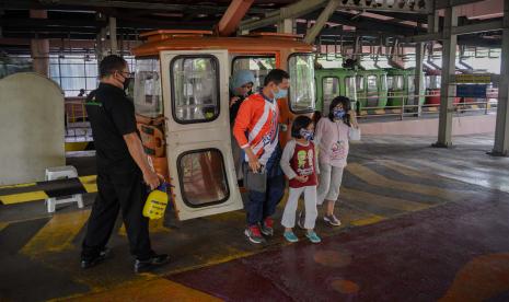 Pengunjung menaiki kereta gantung di area Taman Mini Indonesia Indah (TMII) di Jakarta.