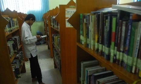 Pengunjung mencari buku di Perpustakaan 