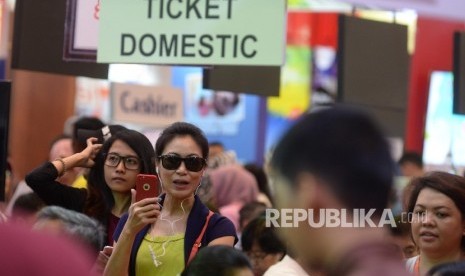 Pengunjung mencari info pemesanan tiket pada pameran Garuda Indonesia Travel Fair (GATF) di Jakarta Convention Centre, Jakarta, Jumat (22/9).