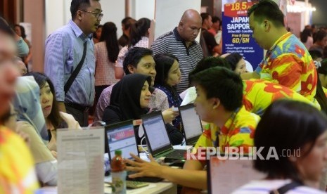 Pengunjung mencari info pemesanan tiket pada pameran Garuda Indonesia Travel Fair (GATF) di Jakarta Convention Centre, Jakarta, Jumat (22/9). 