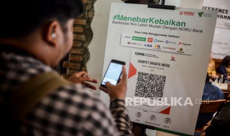 Pengunjung mencoba berzakat menggunakan teknologi QRIS di Jakarta, Senin (9/3). Dompet Dhuafa bekerja sama dengan Nobu Bank dalam memberikan layanan kemudahan kepada masyarakat Indonesia dalam menyalurkan donasi zakat, infak dan wakaf melalui fitur yang dimiliki Nobu Bank. Salah satunya ketersediaan 1.500 QRIS yang disebar ke mitra rekanan dan tempat strategis lainnya untuk dijadikan metode pembayaran zakat, infak dan wakaf ke Dompet Dhuafa. (Republika/Putra M Akbar)