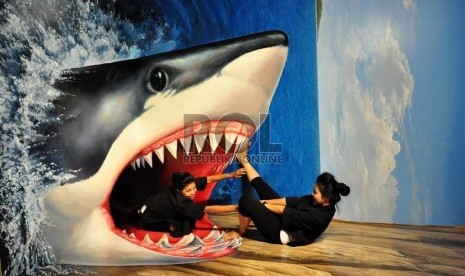 Pengunjung mencoba salah satu lukisan dalam pameran lukisan 3 dimensi Trick Art Japan di Grand Indonesia, Jakarta Pusat, Ahad (2/11). (Republika/Rakhmawaty)