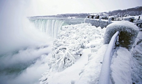 Pengunjung mengabadikan pemandangan Air Terjun Horseshoe di Air Terjun Niagara, Ontario yang membeku, Jumat (29/12).